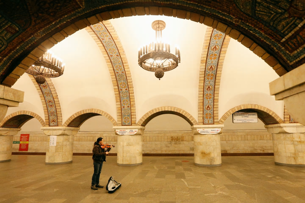 Một nhạc c&ocirc;ng chơi violin trong l&uacute;c chờ chuyến t&agrave;u cuối c&ugrave;ng trước khi t&agrave;u điện ngầm dừng hoạt động, ga Zoloti Vorota, trung t&acirc;m Kyiv, Ukraine, ng&agrave;y 17/3. Ảnh: Reuters.